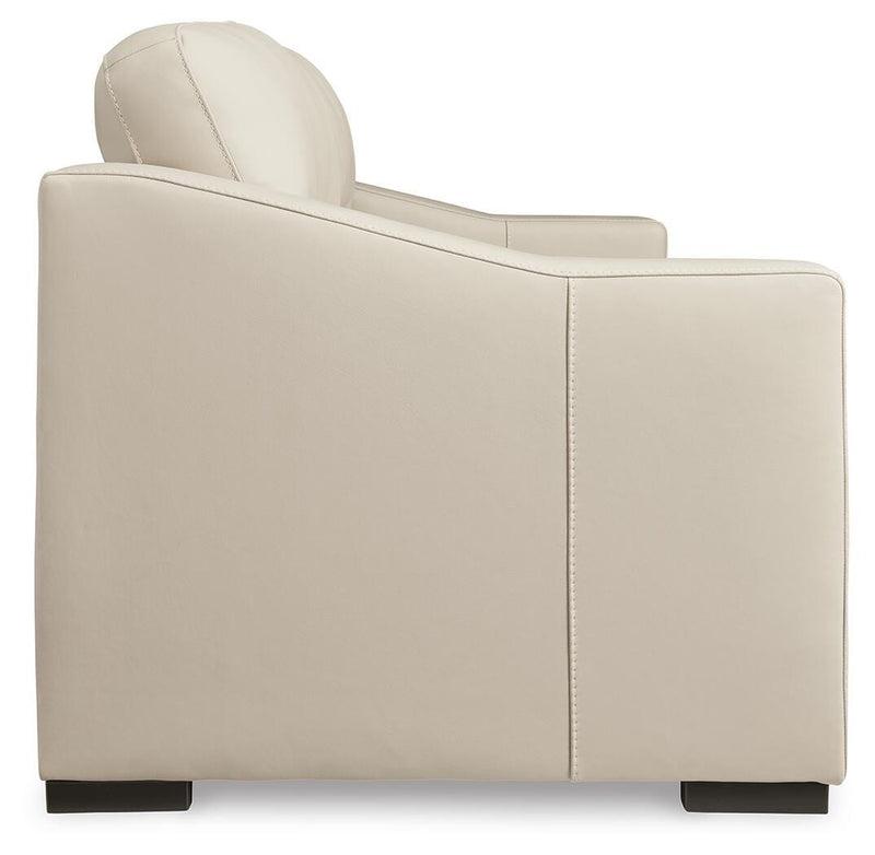 Ashley Furniture Treasure Trove sofa with beige upholstery and plush cushions, shown from a side angle.