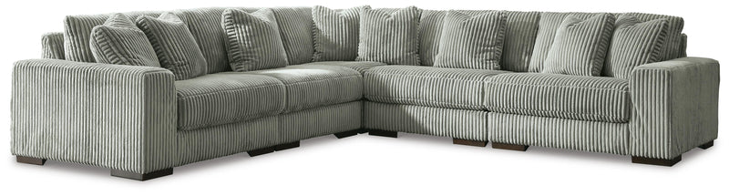 Ashley Furniture Lindyn living room set with sofa, loveseat, and armchair in neutral fabric, arranged in a modern living space.