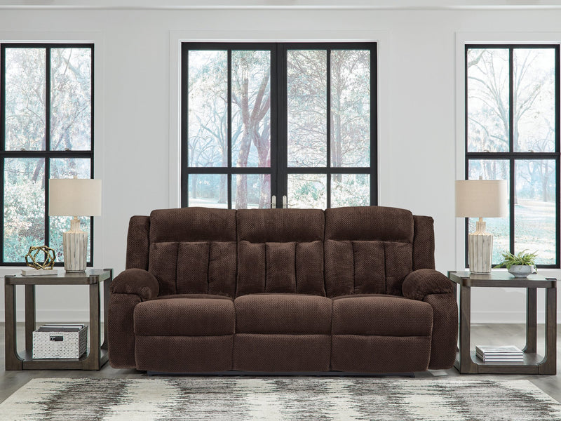 Ashley Furniture observation power reclining sofa with drop-down table, plush fabric, and built-in cup holders in a modern living room.