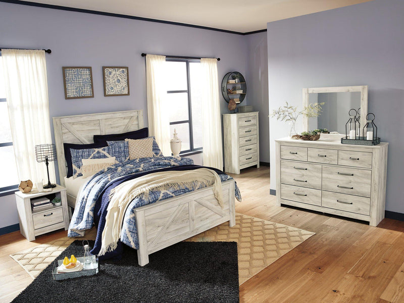 Ashley Furniture Bellaby Crossbuck Bed featuring a wooden frame with crossbuck headboard in a modern bedroom setting
