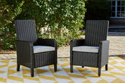 Set of two Ashley Furniture Beachcroft outdoor arm chairs with cushions, featuring woven design and comfortable seating for outdoor dining.