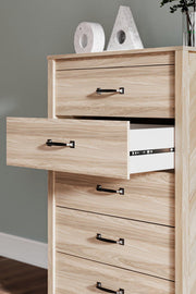 Ashley Furniture Battelle chest of drawers showing six spacious wooden drawers with sleek handles in a modern bedroom setting.
