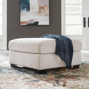 Oversized Ashley Furniture Aviemore accent ottoman with plush fabric and sturdy wooden legs in a modern living room setting.