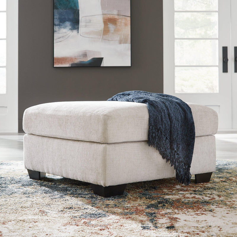 Oversized Ashley Furniture Aviemore accent ottoman with plush fabric and sturdy wooden legs in a modern living room setting.