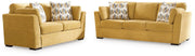 Ashley Furniture Keerwick living room set with sofa and armchair in a modern living space, featuring neutral upholstery and wooden accents.