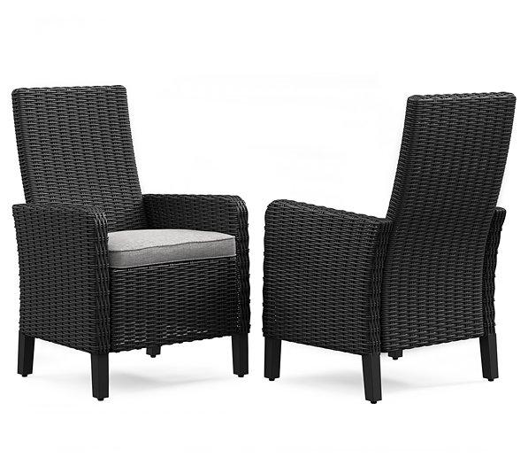 Pair of Ashley Furniture Beachcroft outdoor arm chairs with cushions, designed for comfortable outdoor dining and lounging.