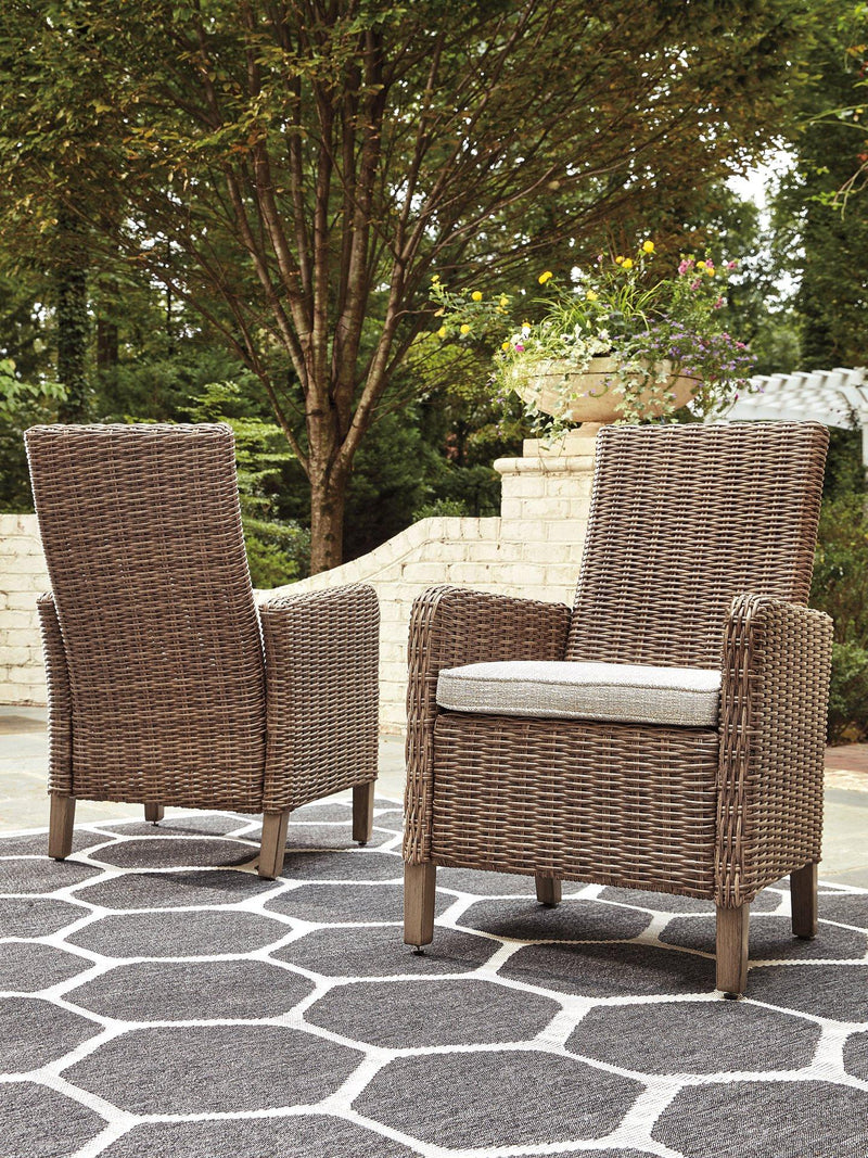 Set of two Ashley Furniture outdoor dining arm chairs with cushions, featuring woven design and sturdy metal frames for patio use.