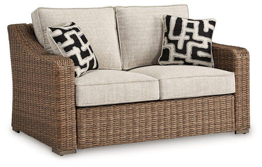 Ashley Furniture Beachcroft outdoor loveseat with cushion, featuring a sturdy frame and comfortable seating for outdoor relaxation.