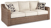 Ashley Furniture Beachcroft outdoor sofa with cushions, featuring a stylish outdoor seating area with plush cushions and weather-resistant frame.