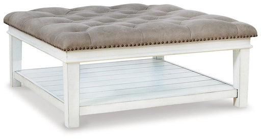 Ashley Furniture Kanwyn upholstered ottoman coffee table with fabric upholstery and sturdy wooden legs, serving as a stylish cocktail table.