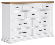 Ashbryn dresser by Ashley Furniture with multiple drawers and a dark wood finish, shown in a modern bedroom setting.