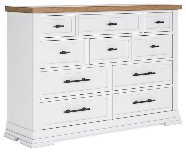 Ashbryn dresser by Ashley Furniture with multiple drawers and a dark wood finish, shown in a modern bedroom setting.