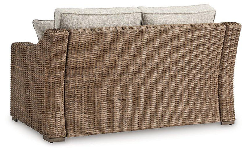 Ashley Furniture Beachcroft outdoor loveseat with cushion, featuring comfortable seating and stylish design for patio or garden use.