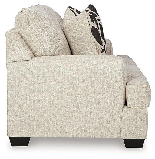 Ashley Furniture Heartcort living room set featuring a sofa, loveseat, and matching armchair with neutral upholstery and wooden legs.