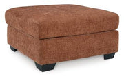 A large Ashley Furniture Aviemore oversized accent ottoman with a plush fabric surface and wooden block legs on a neutral rug.