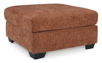 A large Ashley Furniture Aviemore oversized accent ottoman with a plush fabric surface and wooden block legs on a neutral rug.