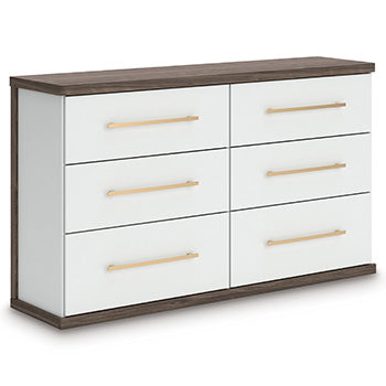 Ashley Furniture Kendanport Dresser with multiple drawers, shown from an angled view in a modern bedroom setting.