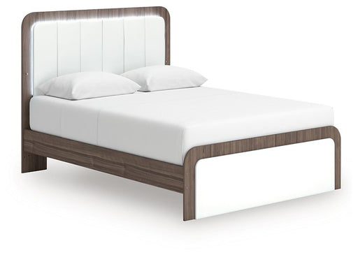 Ashley Furniture Kendanport upholstered bed with a plush headboard and neutral fabric, shown from an angled side view.