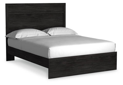 Ashley Furniture Belachime Bed with a stylish wooden frame and intricate headboard design, shown from an angled side view.