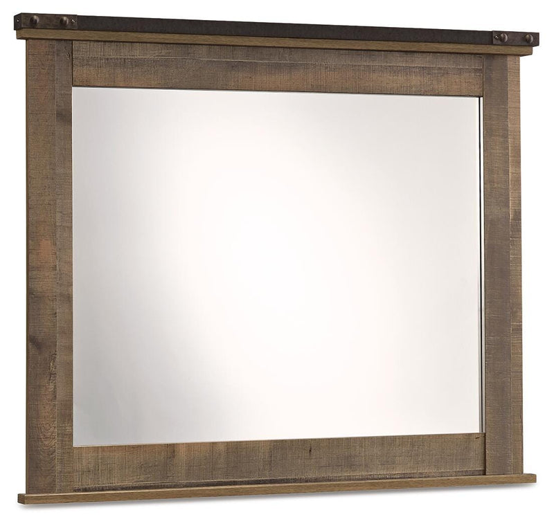 Ashley Furniture Trinell bedroom mirror hanging on a wall with a sleek wooden frame, reflecting a modern bedroom decor.