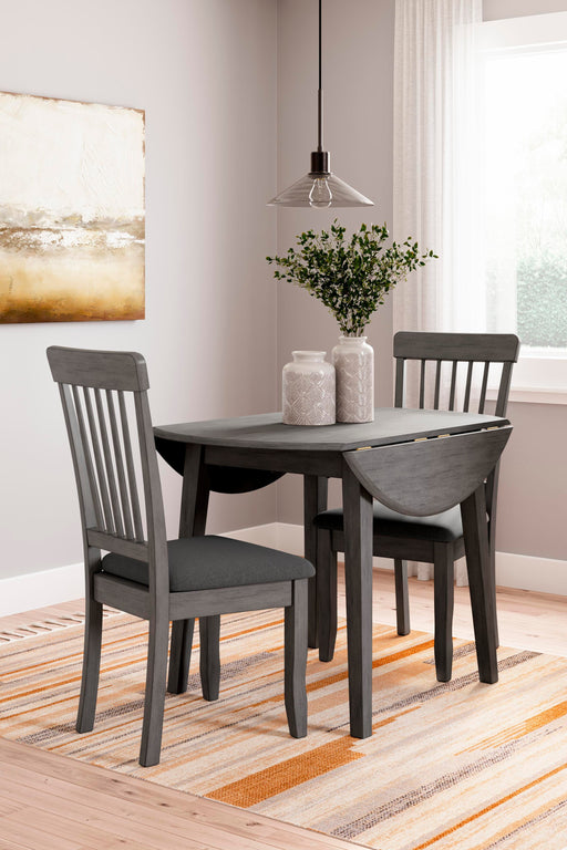 Ashley Furniture Shullden dining room set with a wooden table and matching chairs, shown in a modern dining space.