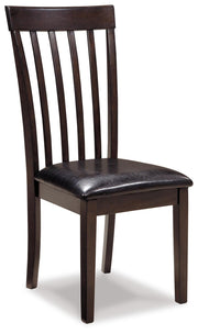 Ashley Furniture Hammis Dining Chair Set featuring four upholstered brown chairs with wooden legs on a sleek dining table.
