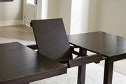 Ashley Furniture Neymorton dining room set with a leaf-shaped table and matching chairs, featuring elegant wood finish and classic design.