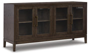 Ashley Furniture Burkhaus dining room set with a round table and six upholstered chairs, shown from an angled view.