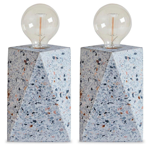Ashley Furniture Maywick Table Lamp Set with two modern lamps featuring textured bases and fabric shades on a wooden surface.