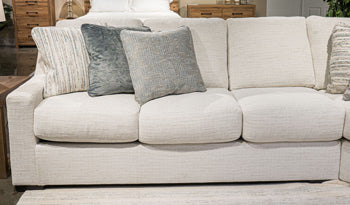 Ashley Furniture Accomplished sectional sofa with plush cushions and modern design, shown in a spacious living room setting.
