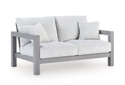 Outdoor table set with chairs from the Hurley Park Ashley Furniture outdoor package, shown from an angled side view.