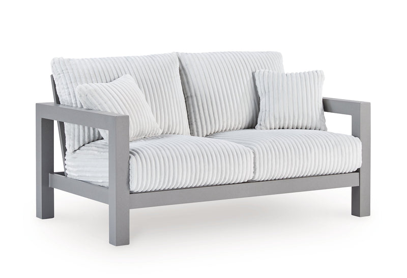 Outdoor table set with chairs from the Hurley Park Ashley Furniture outdoor package, shown from an angled side view.