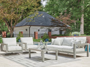 Ashley Furniture Hurley Park outdoor table set with a rectangular wooden table and matching chairs in a garden setting